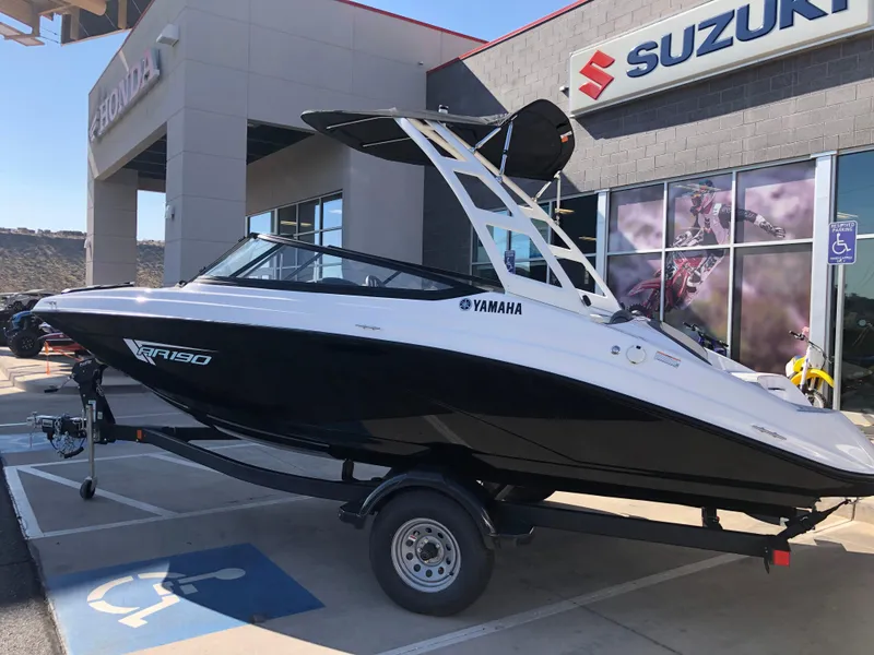 Slide: The Image of 2025 Yamaha AR190 boat on trailer outside Suzuki dealership. - 44