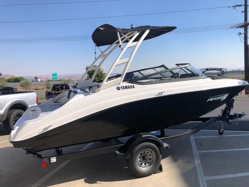 Slide: The Image of 2025 Yamaha AR190 boat on trailer, parked outdoors, side view. - 45