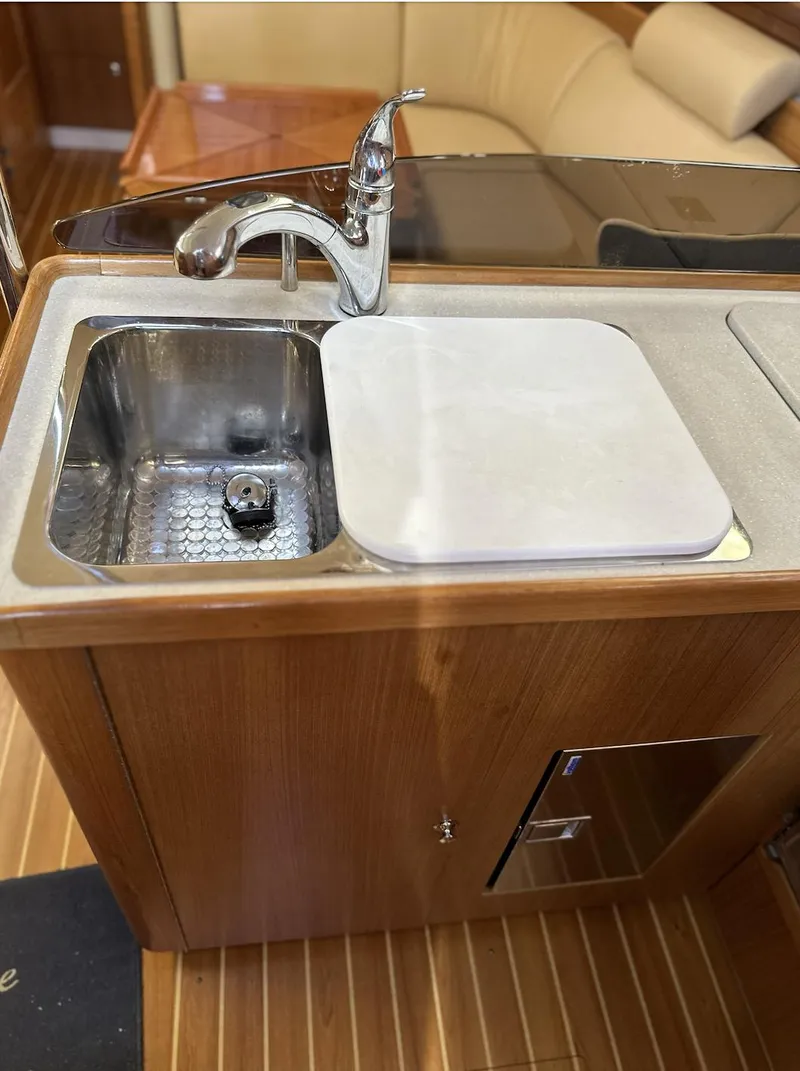 Slide: The Image of 2013 Catalina 355 yacht kitchen sink with wooden cabinetry and modern faucet. - 23