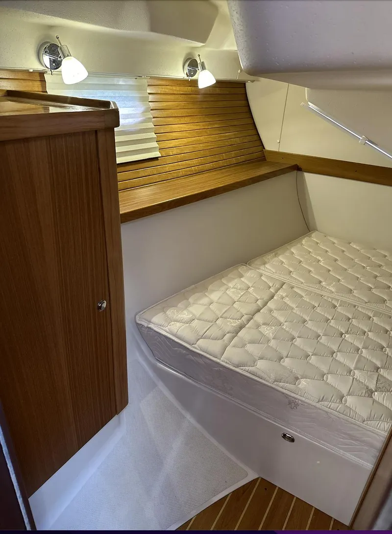 Slide: The Image of 2013 Catalina 355 yacht interior with cozy cabin bed and wooden accents. - 25
