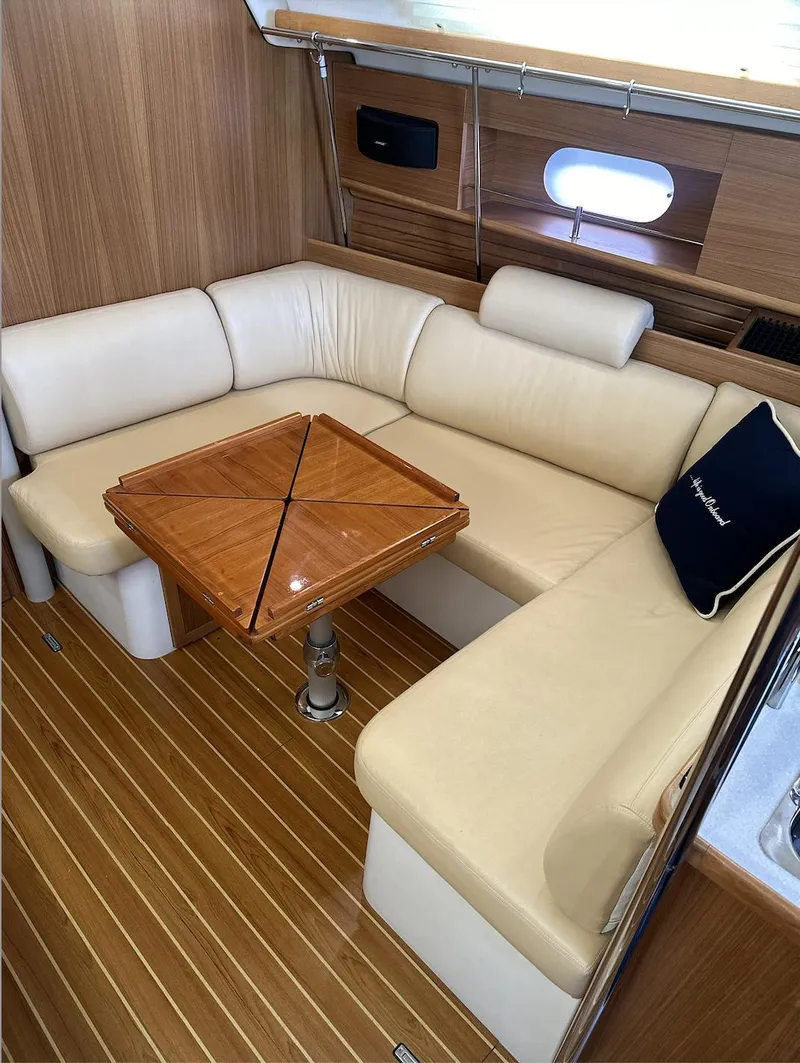 Slide: The Image of 2013 Catalina 355 yacht interior with beige seating and wooden table. - 27