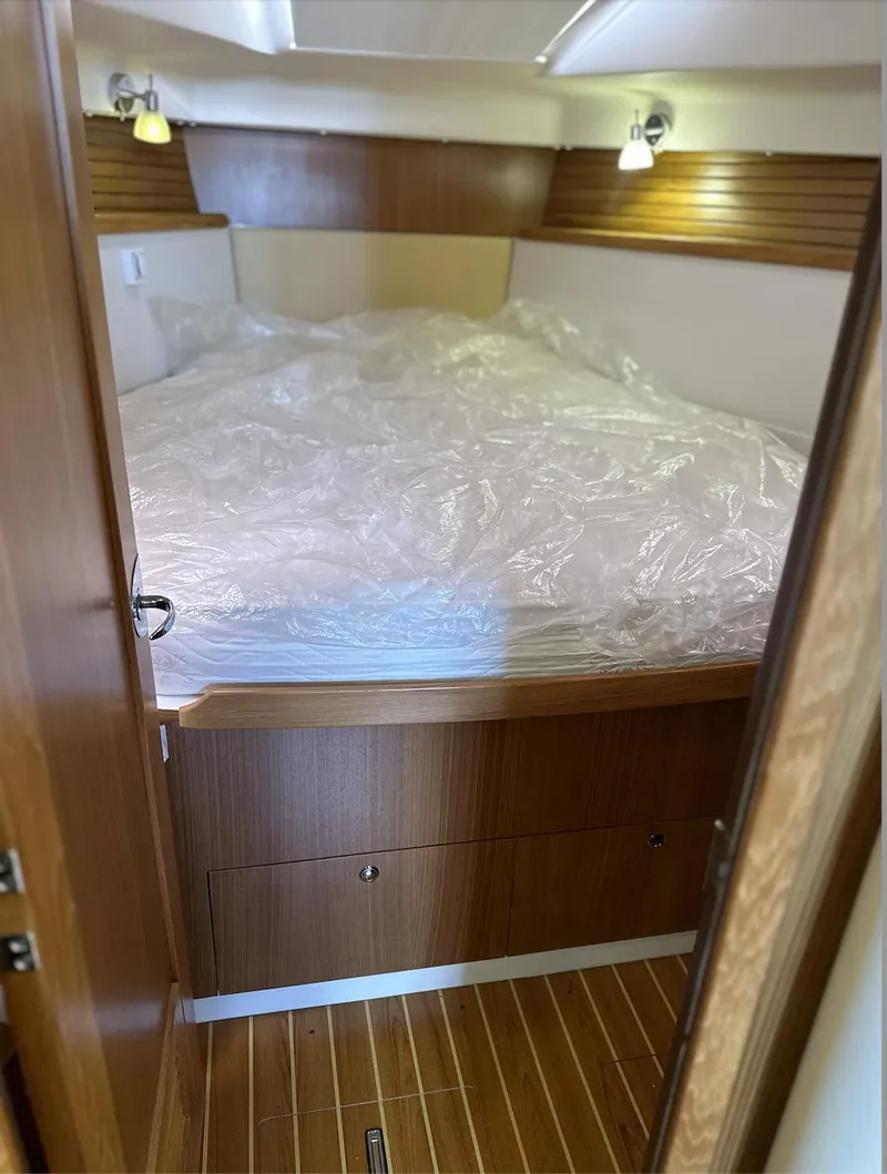 Slide: The Image of 2013 Catalina 355 yacht cabin with wooden interior and cozy bed. - 28