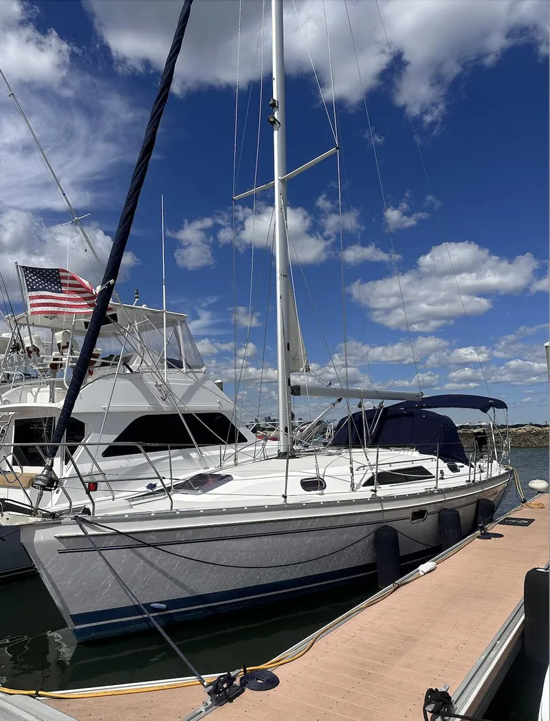 Slide: The Image of 2013 Catalina 355 sailboat docked under a blue sky with clouds. - 3