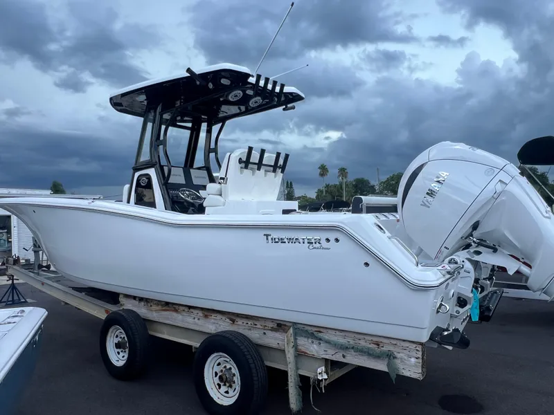 Slide: The Image of 2025 Tidewater 272 CC Adventure boat on trailer under cloudy sky. - 0