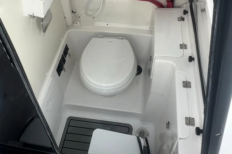 Slide: The Image of 2025 Tidewater 272 CC Adventure boat interior bathroom with toilet and storage compartments. - 12
