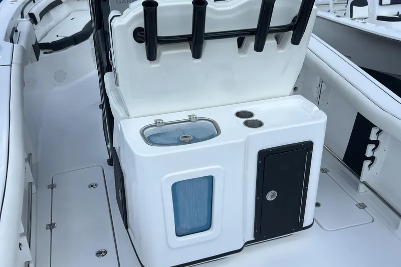 Slide: The Image of Tidewater 272 CC Adventure 2025 boat interior with fishing rod holders and sink. - 19