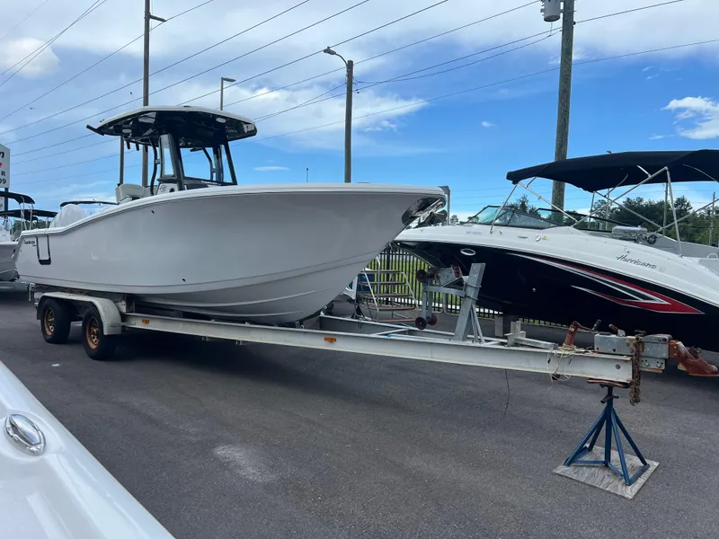 Slide: The Image of 2025 Tidewater 272 CC Adventure boat on trailer, parked outdoors. - 3