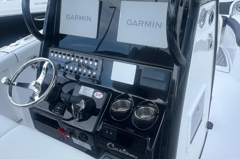 Slide: The Image of 2025 Tidewater 272 CC Adventure boat dashboard with Garmin displays and controls. - 7