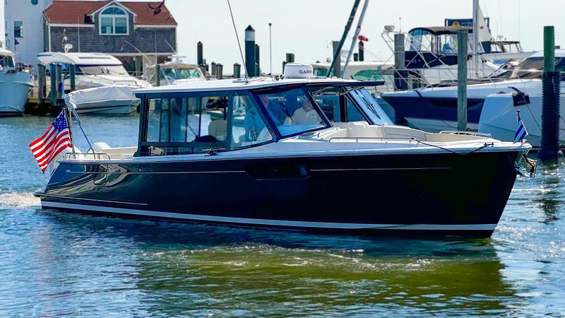 Slide: The Image of 2024 MJM 3 boat cruising in a marina with American flag. - 1