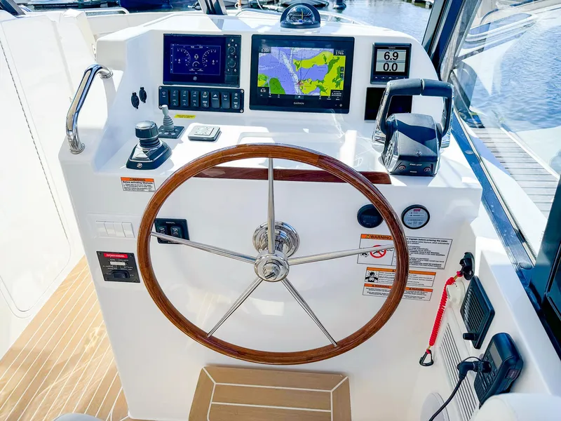 Slide: The Image of 2024 MJM 3 boat helm with navigation screens and wooden steering wheel. - 12