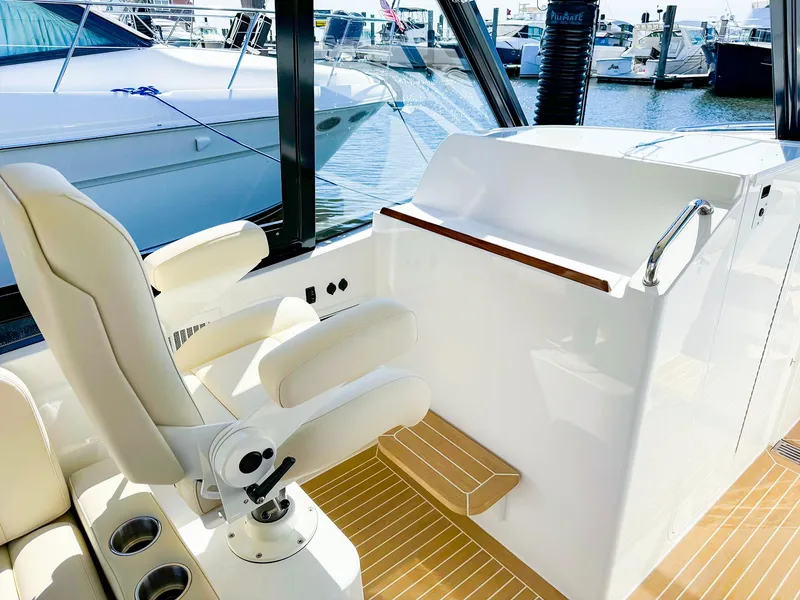 Slide: The Image of 2024 MJM 3 boat interior with helm seat and marina view. - 19