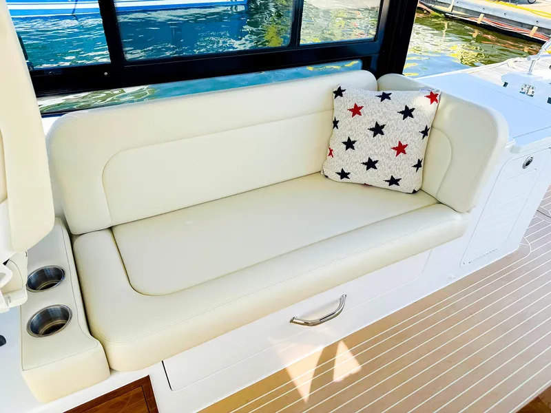 Slide: The Image of 2024 MJM 3 boat interior with white seating and star-patterned pillow. - 21