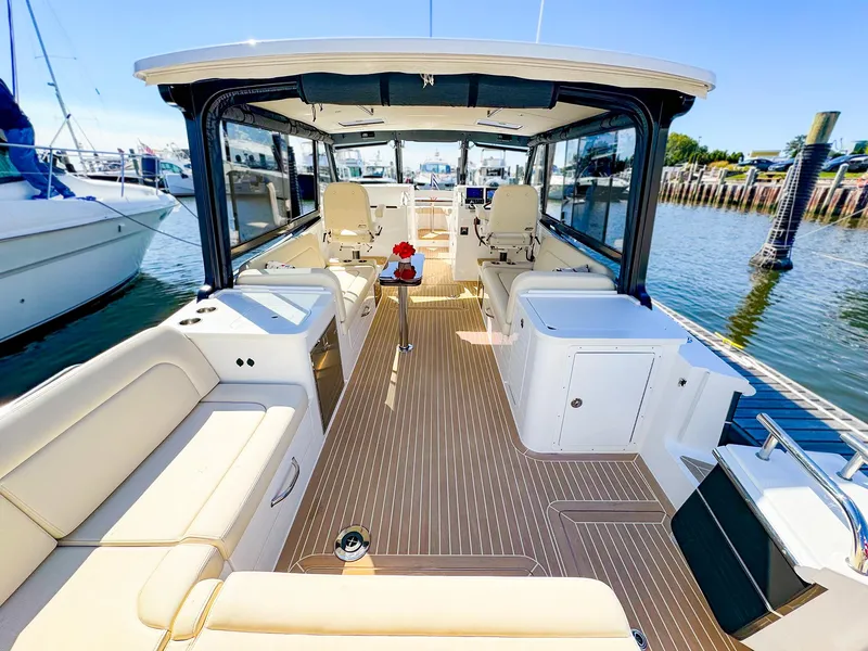 Slide: The Image of 2024 MJM 3 boat interior with spacious seating and modern design at a marina. - 24