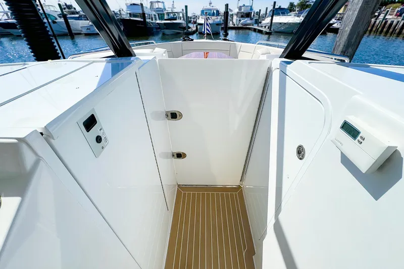 Slide: The Image of 2024 MJM 3 boat interior with sleek white design and wood flooring at a marina. - 29