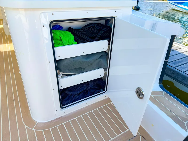 Slide: The Image of Open storage compartment on 2024 MJM 3 boat with ropes and gear. - 30