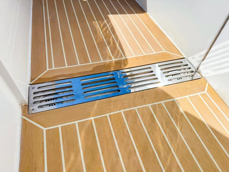 Slide: The Image of 2024 MJM 3 boat deck with teak flooring and metal drainage grate. - 36