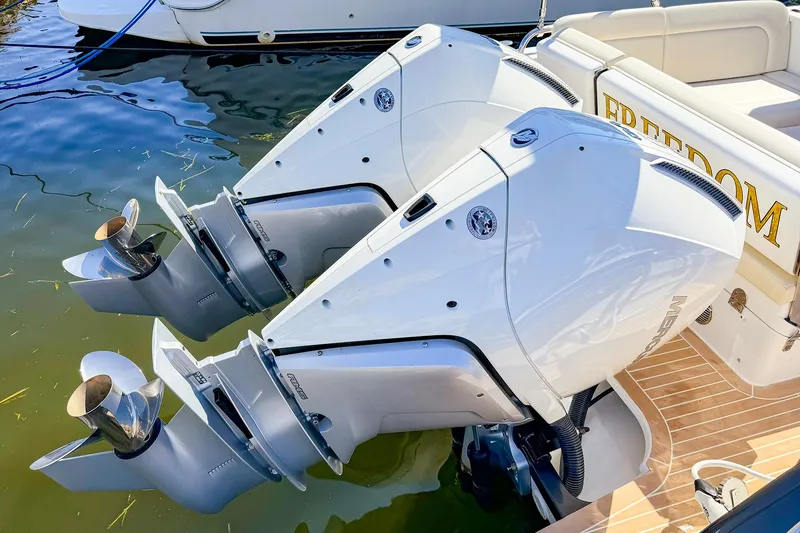Slide: The Image of Twin outboard motors on a 2024 MJM 3 boat, docked in water. - 5