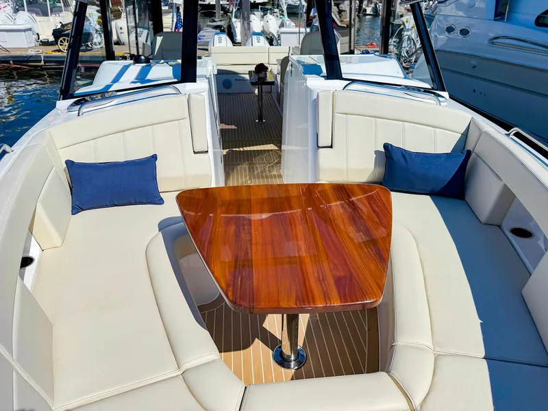 Slide: The Image of 2024 MJM 3 boat interior with elegant wood table and cushioned seating. - 7