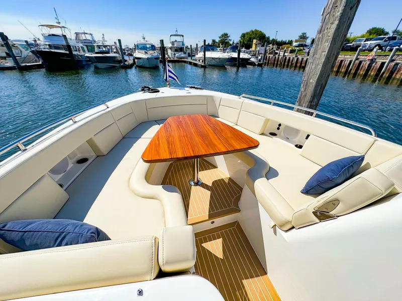 Slide: The Image of 2024 MJM 3 boat with elegant seating and wooden table in a marina setting. - 8