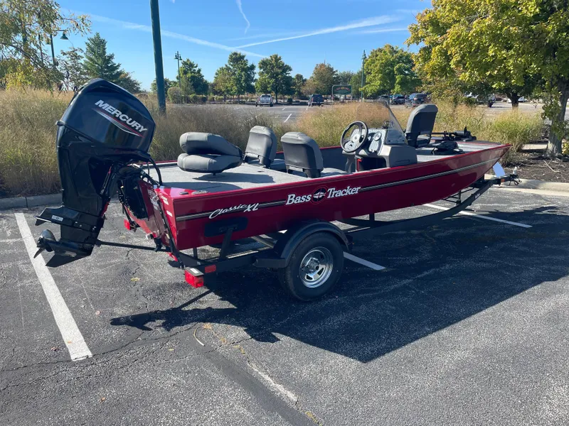 Slide: The Image of 2025 Tracker Bass Tracker Classic XL boat in parking lot, red exterior, Mercury engine. - 3