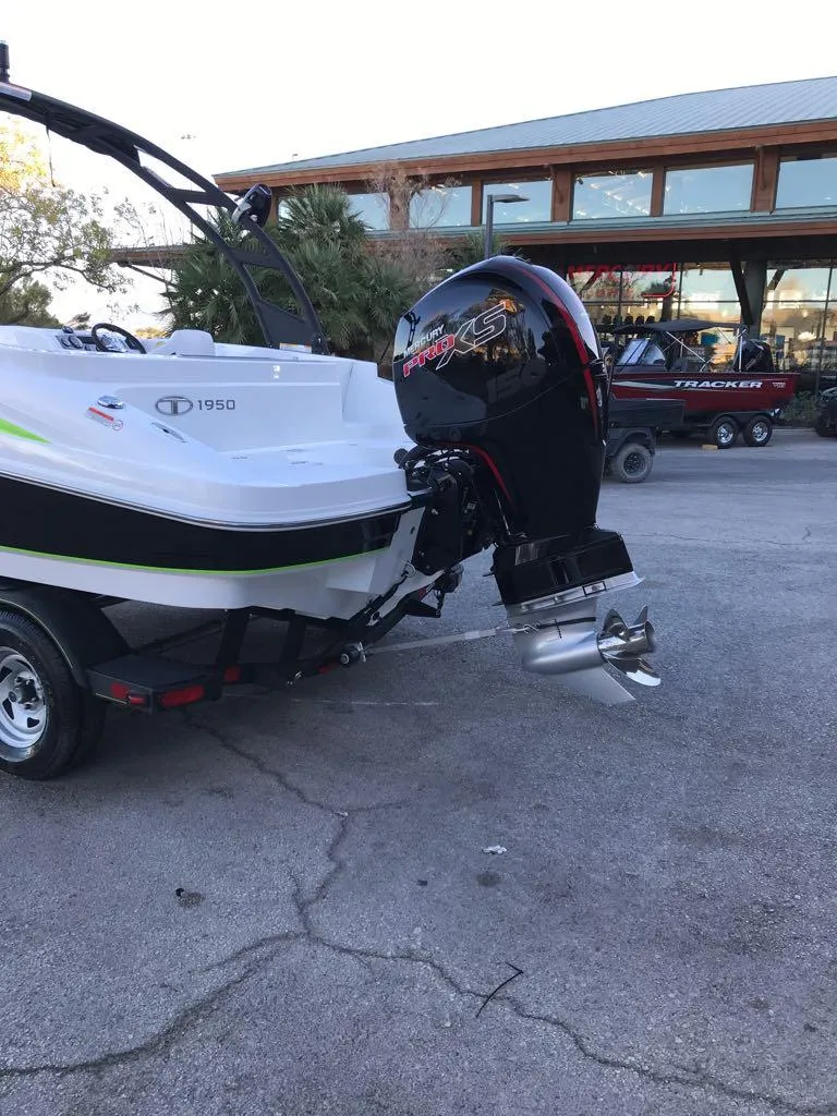 Slide: The Image of 2024 Tahoe 1950 boat with powerful outboard motor in a parking area. - 9