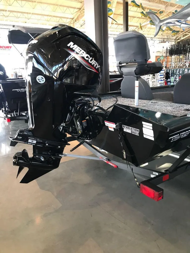 Slide: The Image of 2025 Tracker Pro Team 175 boat with Mercury outboard motor in showroom. - 2