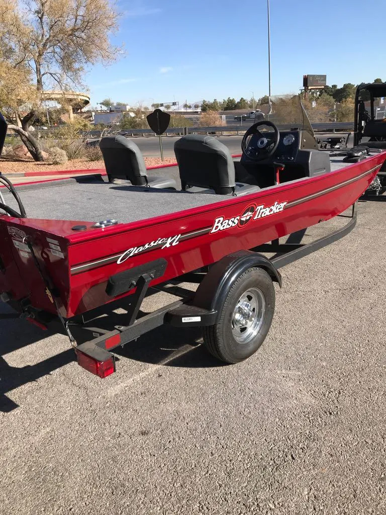 Slide: The Image of 2025 Tracker Bass Tracker Classic XL boat with 50 HP engine, parked outdoors. - 5