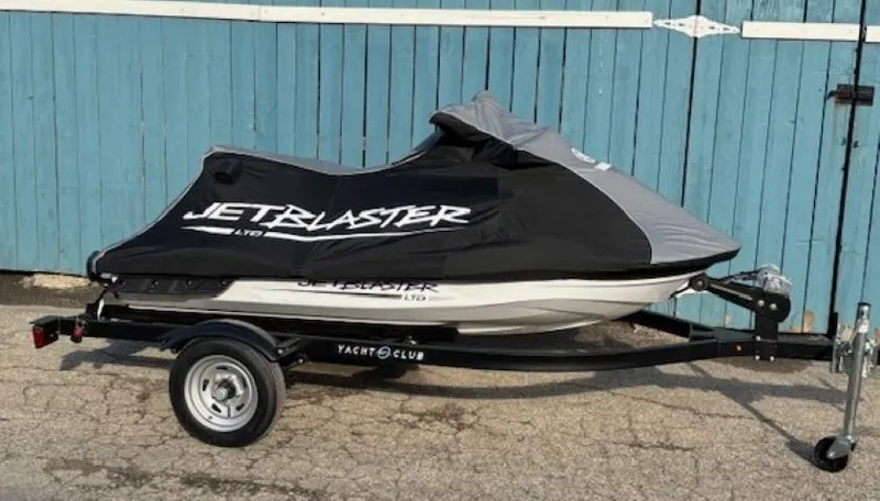 Slide: The Image of 2025 Yamaha WaveRunner JetBlaster LTD on trailer, covered, parked by blue wooden doors. - 5
