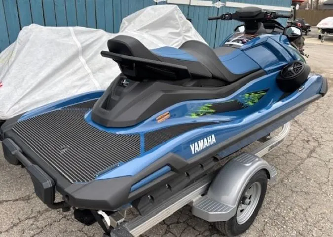 Slide: The Image of 2025 Yamaha WaveRunner VX Cruiser HO on trailer, blue color, parked outdoors. - 2
