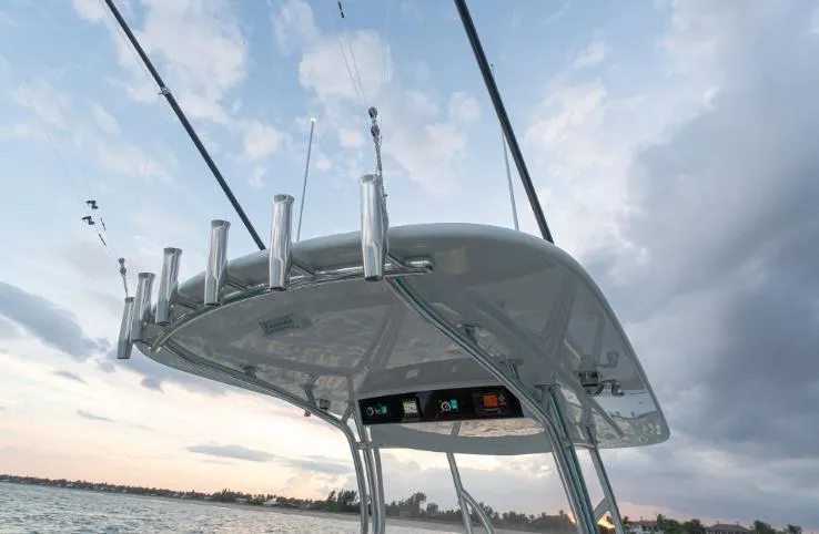 Slide: The Image of Valhalla Boatworks V 37, 2025 model, fishing rods on T-top against cloudy sky. - 7