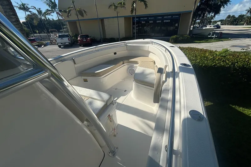 Slide: The Image of 2025 Bulls Bay 255CC boat interior with seating and storage, parked outdoors. - 9