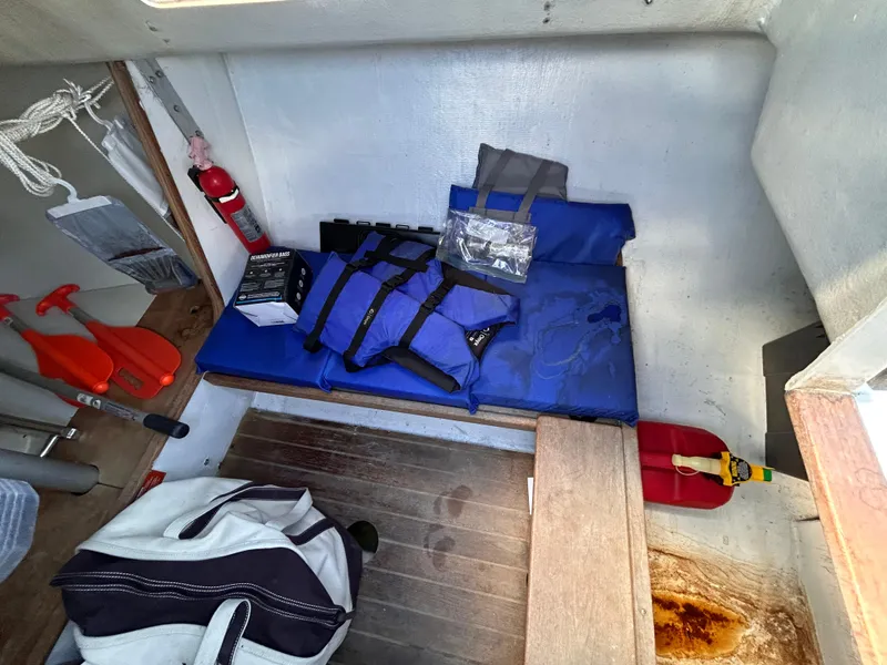 Slide: The Image of Interior of 1991 J Boats J/22 with safety gear and storage items. - 22