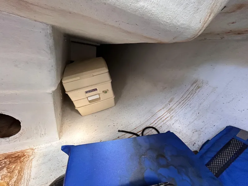 Slide: The Image of Interior of 1991 J Boats J/22 sailboat with portable toilet and blue cushion. - 25