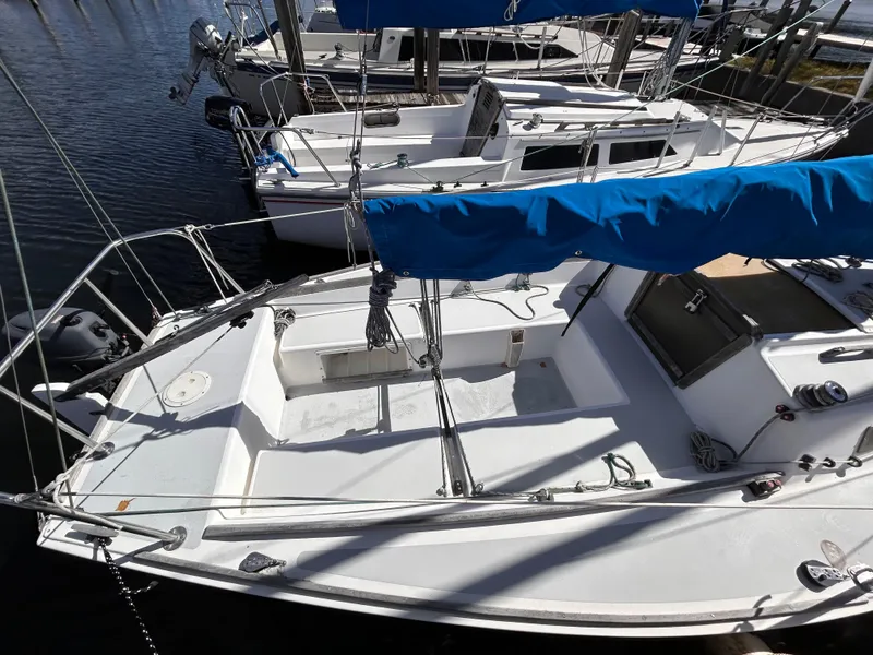 Slide: The Image of 1991 J Boats J/22 sailboat docked, featuring a clean white deck and blue sail cover. - 3