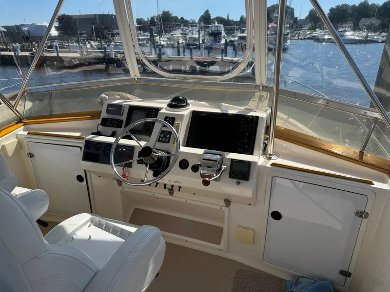 Slide: The Image of 2004 Nauset 33 boat cockpit with steering wheel and navigation equipment, docked at marina. - 12
