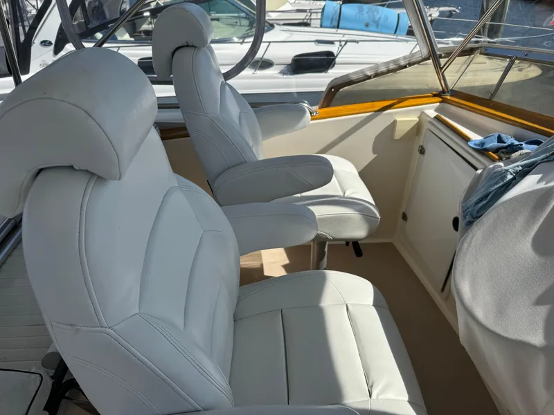 Slide: The Image of 2004 Nauset 33 boat interior with white leather seats and wooden trim. - 15