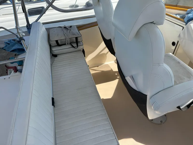Slide: The Image of 2004 Nauset 33 boat interior with white seating and helm chairs. - 16