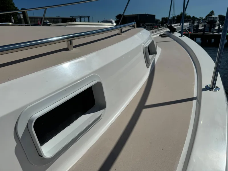 Slide: The Image of 2004 Nauset 33 boat deck with railings and vents in a marina setting. - 18