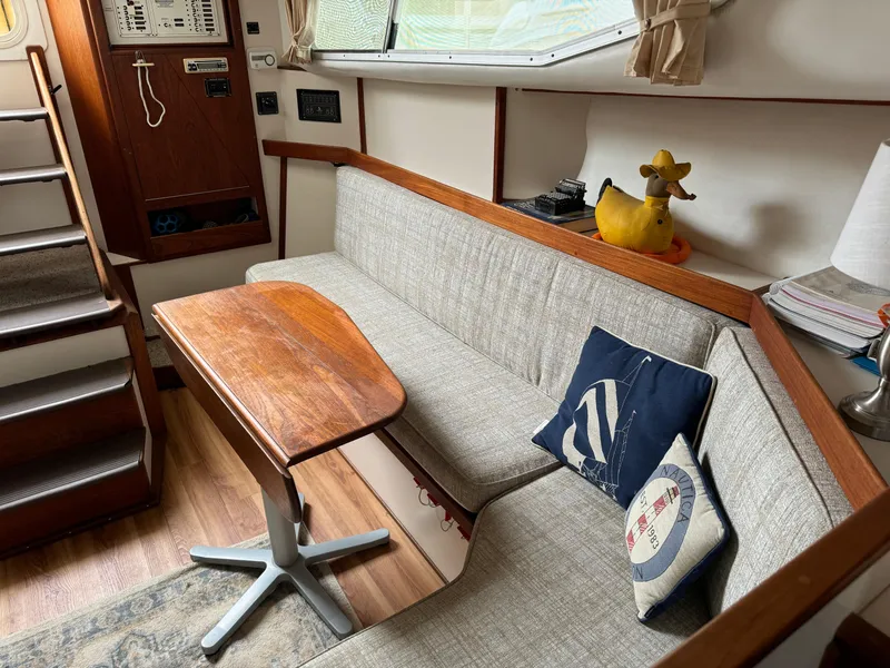 Slide: The Image of Cozy 2004 Nauset 33 boat interior with wooden table, cushioned seating, and nautical decor. - 27
