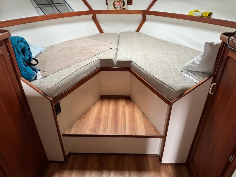 Slide: The Image of Cozy cabin interior of 2004 Nauset 33 boat with cushioned seating and wooden accents. - 29