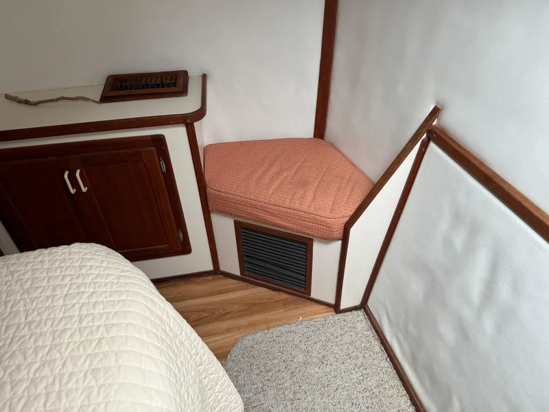 Slide: The Image of 2004 Nauset 33 interior with wood cabinetry, cushioned seat, and white walls. - 37
