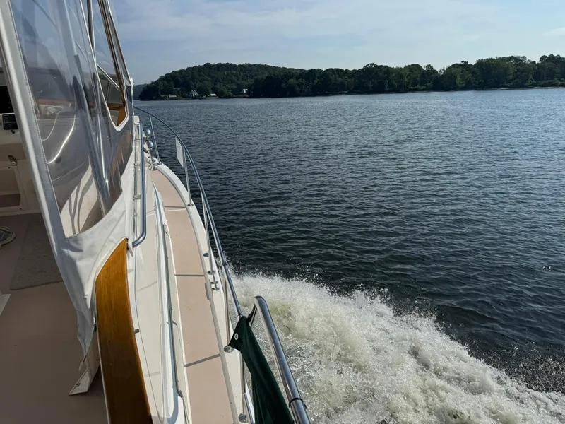 Slide: The Image of Side view of 2004 Nauset 33 Bridge Deck boat cruising on a calm lake. - 48