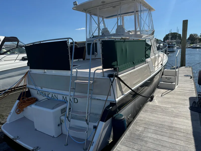 Slide: The Image of 2004 Nauset 33 boat docked at marina, rear view with ladder and canopy. - 5