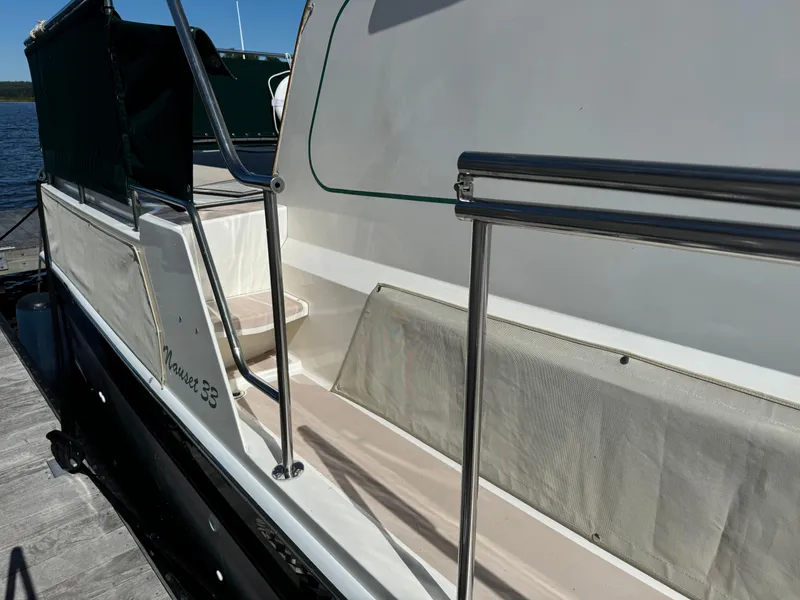 Slide: The Image of 2004 Nauset 33 boat docked, featuring sleek white exterior and stainless steel railings. - 7