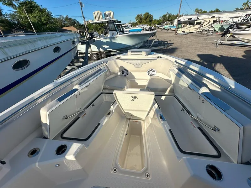 Slide: The Image of 2025 Sailfish 232 boat interior with open compartments and outboard motor in a marina setting. - 12