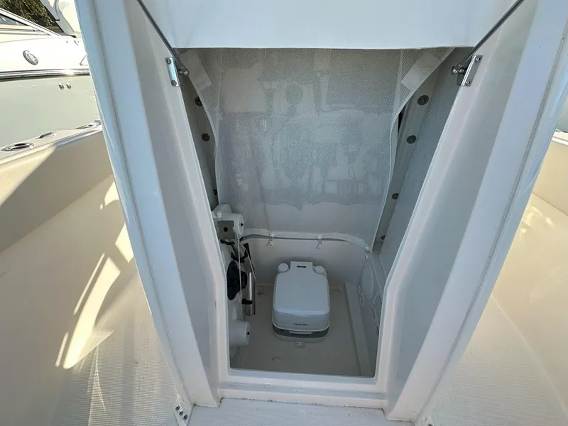 Slide: The Image of 2025 Sailfish 232 boat interior with helm, seating, and controls in a sunny marina. - 15
