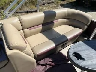 Slide: The Image of 2019 Sweetwater 2286SB boat interior with beige seating and round table. - 7