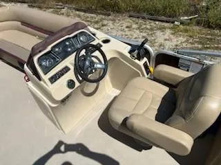 Slide: The Image of 2019 Sweetwater 2286SB boat interior with beige captain's chair and steering console. - 9