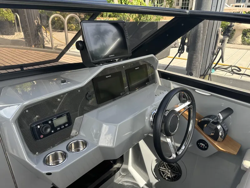 Slide: The Image of 2021 Rand Leisure boat dashboard with steering wheel, navigation screens, and controls. - 12