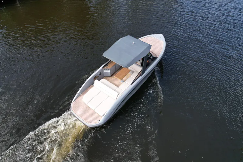 Slide: The Image of 2021 Rand Leisure boat cruising on calm water, featuring sleek design and spacious deck. - 29